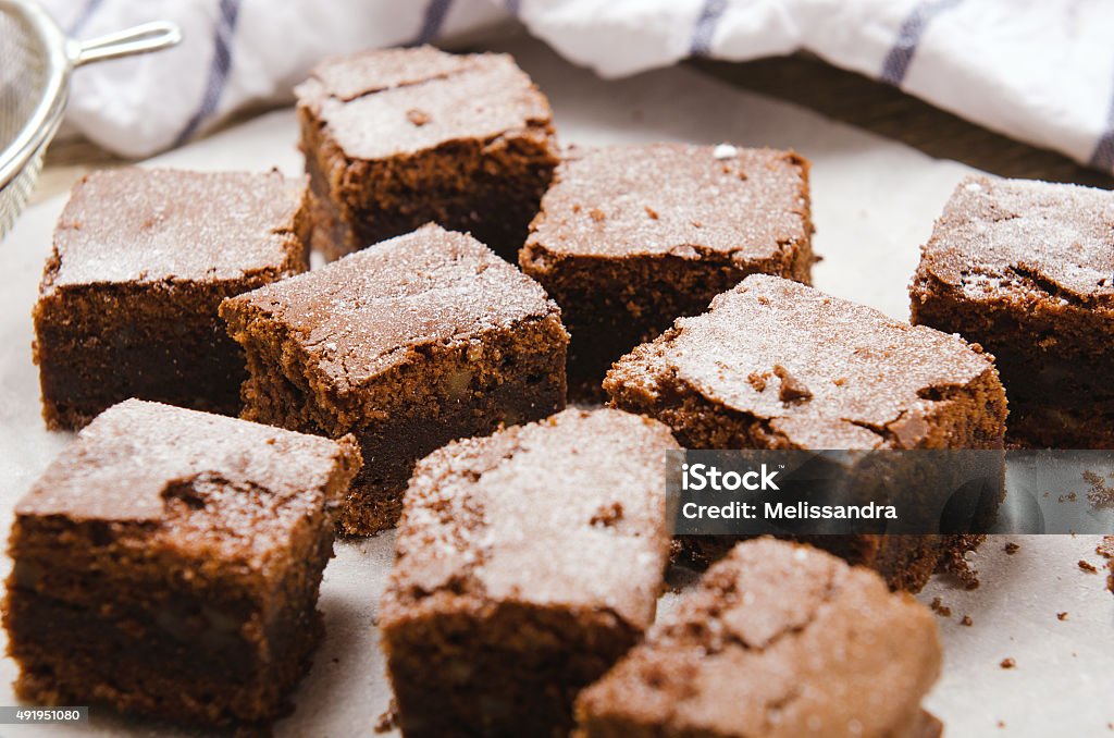 chocolate brownie diced baking paper on wooden table with a chocolate brownie diced on baking paper on a wooden table 2015 Stock Photo