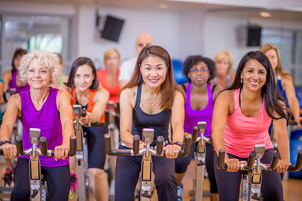 groupe de cyclers en cours de spinning - sporting position vitality blurred motion strength photos et images de collection