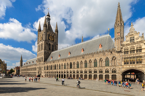 Ypres, Belgium - September 9, 2014: City life in the Grote Markt, with tourists and locals strolling in the main square of the old town, overlooked by beautiful buildings such as the Cloth Hall, a UNESCO World Heritage Site. The city, almost totally destroyed after the First World War, was carefully and faithfully rebuilt.