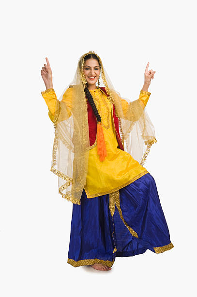 donna in abito giallo tradizionale facendo bhangra punjabi - bhangra foto e immagini stock