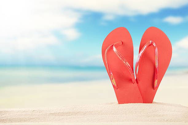 istock Summer beach with red sandals in sand 491959505