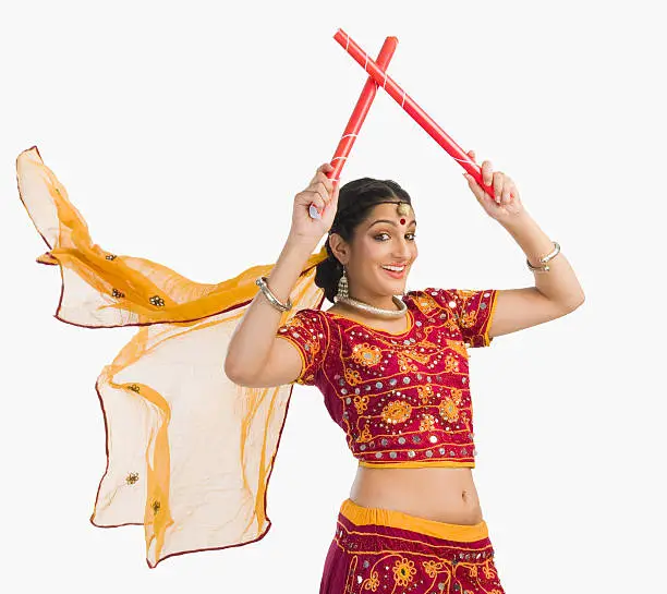Woman in lehenga choli performing dandiya dance