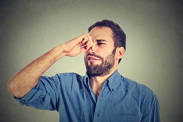 istock man pinches nose with fingers looks with disgust something stinks 491963458