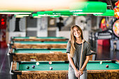 Happiness girl standing in a pub at the pool table