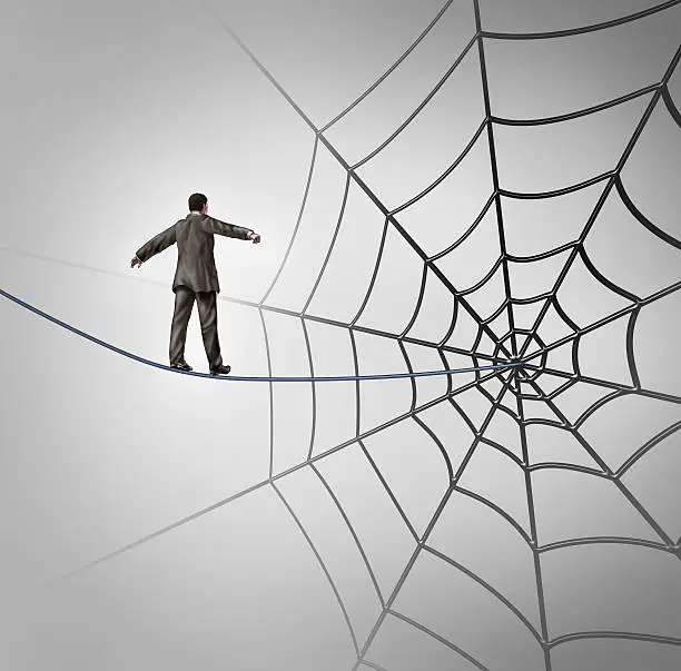 Businessman trap business concept with a tightrope walker walking on a wire leading to a giant spider web as a metaphor for adversity and deception of being lured to a financial ambush or recruiting new career candidates.