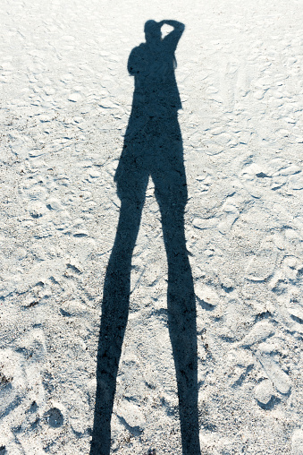 photographers shadow on a beach
