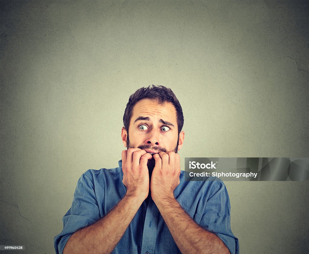 Anxious young man biting his nails fingers freaking out Portrait anxious young man biting his nails fingers freaking out Fear Stock Photo
