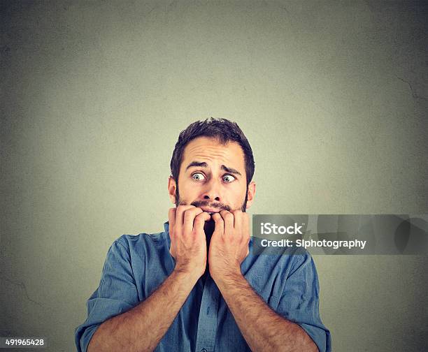 Anxious Young Man Biting His Nails Fingers Freaking Out Stock Photo - Download Image Now