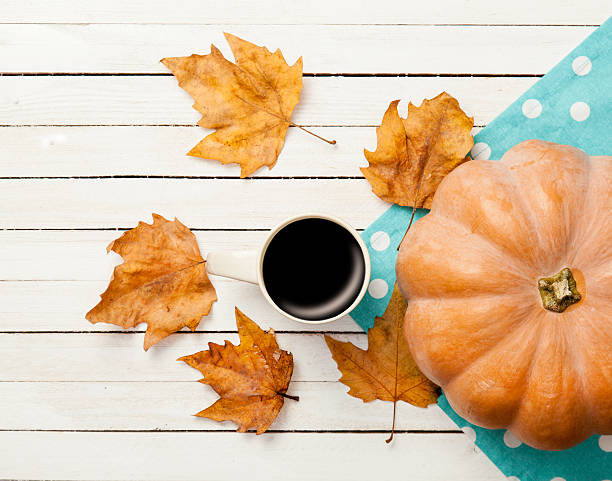 istock Cup of coffee and pumpkin with leafs 491973038