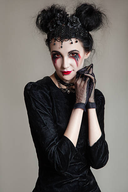 junge wunderschöne gotische frau mit weißer haut, roten lippen. halloween - zombie aggression monster indoors stock-fotos und bilder