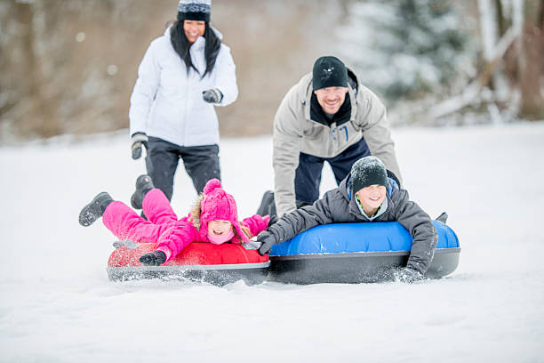 istock Father Pushing Kids on an Inner Tube 491976196