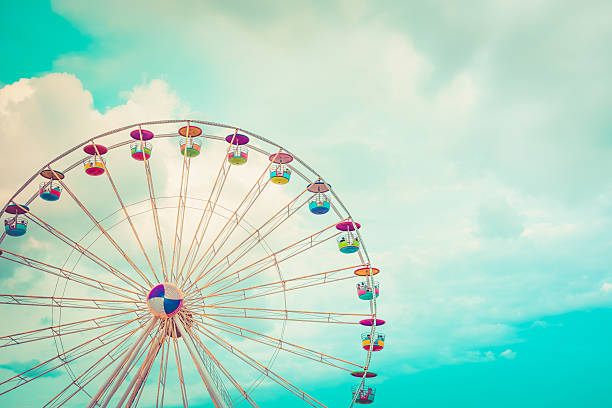 riesenrad an einem wolkigen himmel hintergrund vintage-farbe - riesenrad stock-fotos und bilder