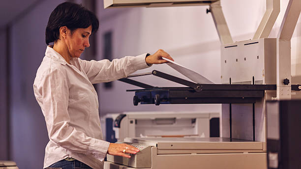 istock Businesswoman scanning and printing document in office 491977594