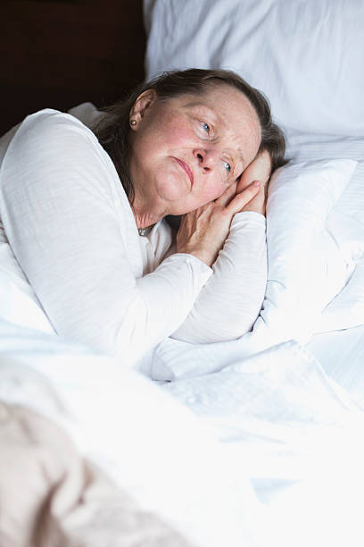 istock Senior woman lying in bed, eyes open 491990340