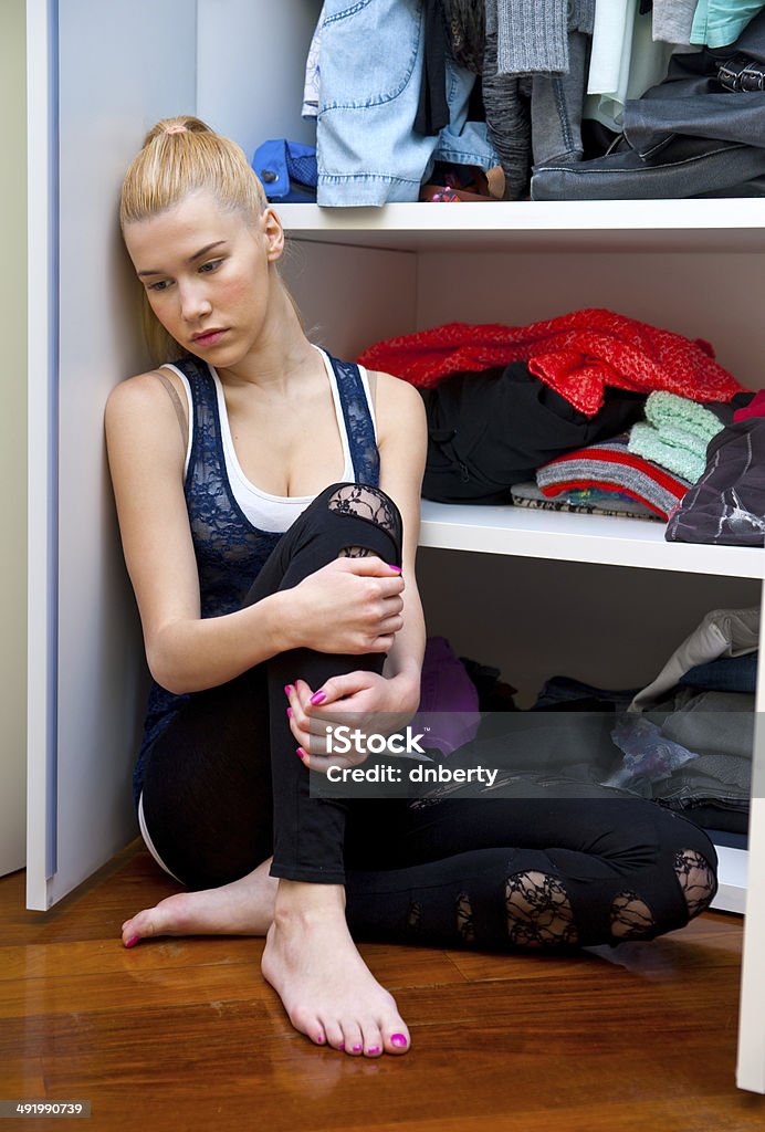 teen girl thinking in front of closet attractive teen girl  in her room in front of closet thinking Adult Stock Photo