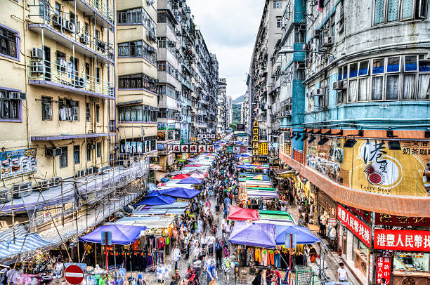 Street Market in Hong Kong, China The busy Fa Yuen street market in Hong Kong, China. The area is popular with tourists and locals for its cheap food and fashion clothing. HDR rendering with long exposure to create crowd motion effect. mong kok stock pictures, royalty-free photos & images