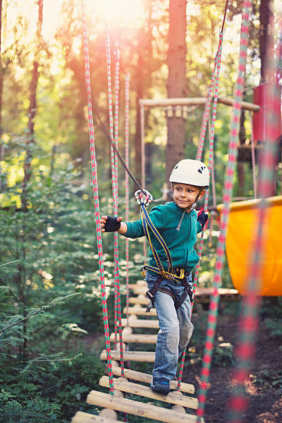 istock Little boy walking on ropes course in outdoors adventure park 491992048