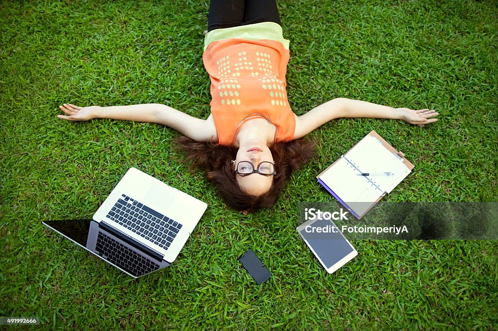 freelancer girl from the device: laptop, tablet, player, noteboo girl sitting in the park with a laptop 2015 Stock Photo