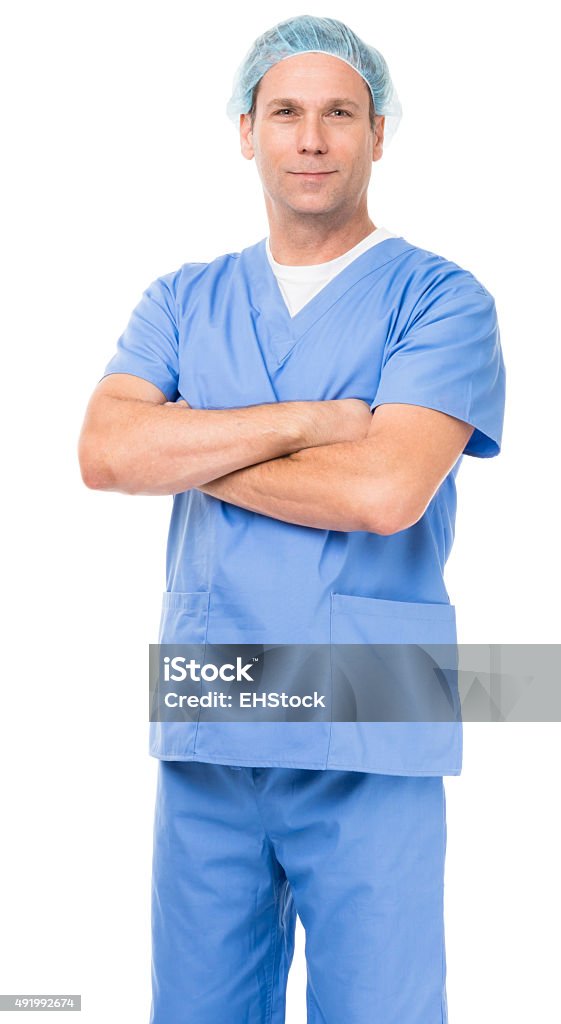 Doctor in scrubs on white Thirtyish male doctor in blue scrubs with arms crossed on white background 2015 Stock Photo