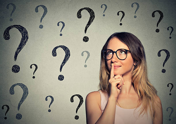 istock woman with glasses looking up at question marks 491994142