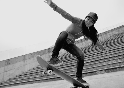 skateboarding woman prepare for jump on stairs