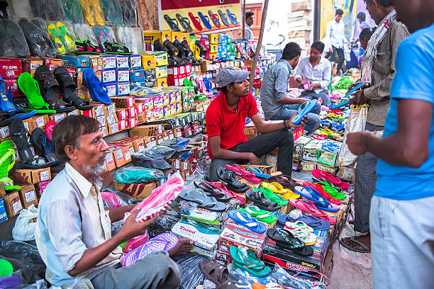 markt in indien: anbieter verkaufen hausschuhe und schuhe - shoe men indian culture indian ethnicity stock-fotos und bilder