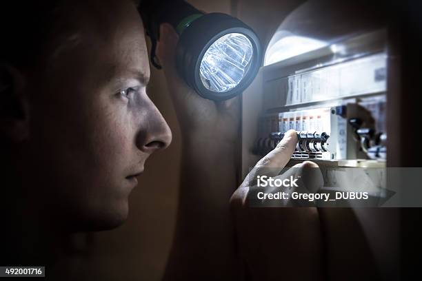 Man Restoring Power On Circuit Breaker After Electricity Outage Stock Photo - Download Image Now