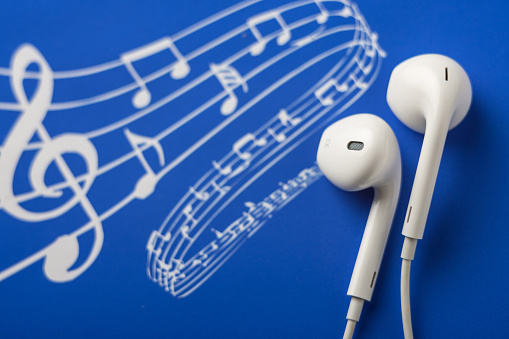 White earphones on blue music notes background