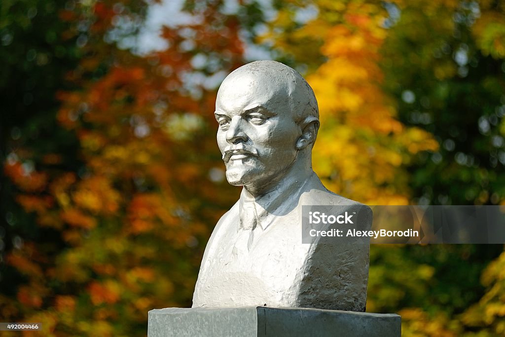Lenin bust monument with autunm leaves on the background Lenin bust monument with autunm leaves on the background horizontal Vladimir Lenin Stock Photo