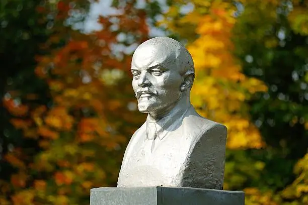 Photo of Lenin bust monument with autunm leaves on the background