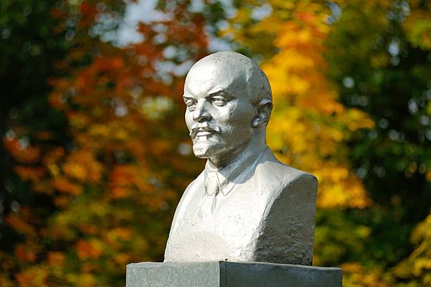 busto de lenine autunm monumento com folhas no fundo - vladimir lenin imagens e fotografias de stock