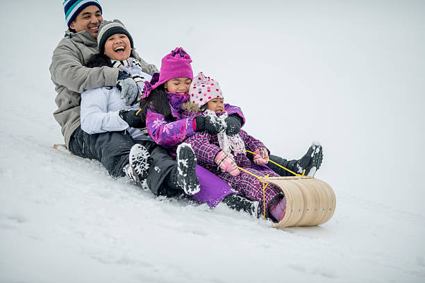 istock Family Riding a Toboggan Down a Snowy Hill 492004710