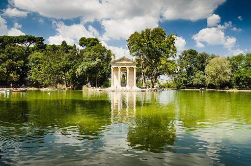 small temple in roman style on the shore of artificial lake on villa borgese garden