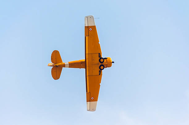 ハーバードビンテージ航空機 midair スタントする - airplane stunt yellow flying ストックフォトと画像