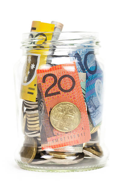 Savings Jar with Australian Money A jar full of Australian money - both coins and notes. Concept for savings and putting some money away. Studio shot on a white background. No people. australian dollar stock pictures, royalty-free photos & images