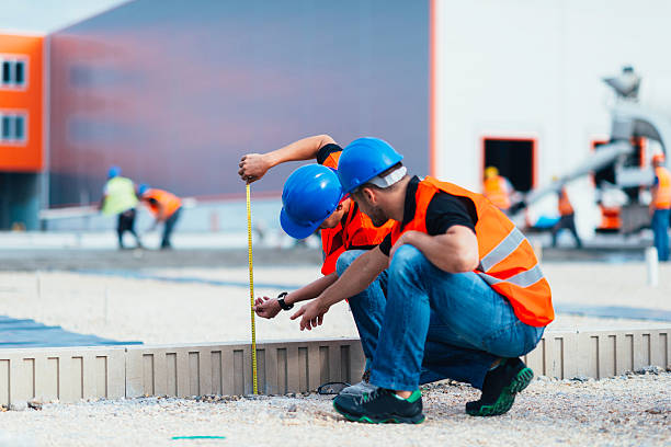 Construction workers Quality inspectors at construction site, workers laying concrete in the background concrete work stock pictures, royalty-free photos & images