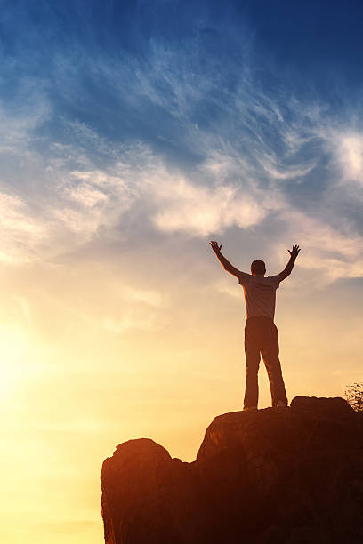 istock Silhouette of a man with raised-up arms at the sunset 492013268