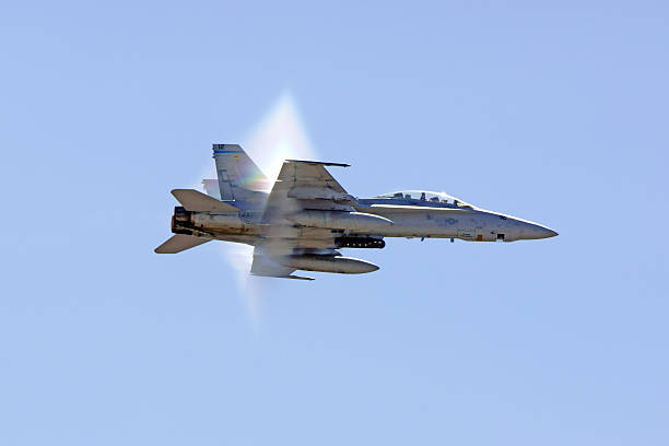 Airplane F-18 Hornet Jet breaking sound barrier Miramar, California,USA- October 3, 2015. F-18 Hornet jet fighter breaking the sound barrier at 2015 Miramar Air Show in San Diego, California. The 2015 Miramar Air Show features 3 days of military aircraft and the US Navy Blue Angels demonstration team performing for the general public. fa 18 hornet stock pictures, royalty-free photos & images