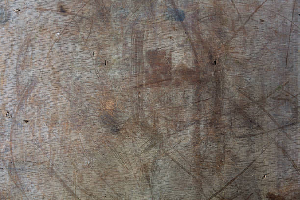 Weathered light wood board partially painted in white. Drops of white color are somewhere leaked. A wood grain pattern featuring even grains of wood running horizontally across the image. The board is old and weathered.