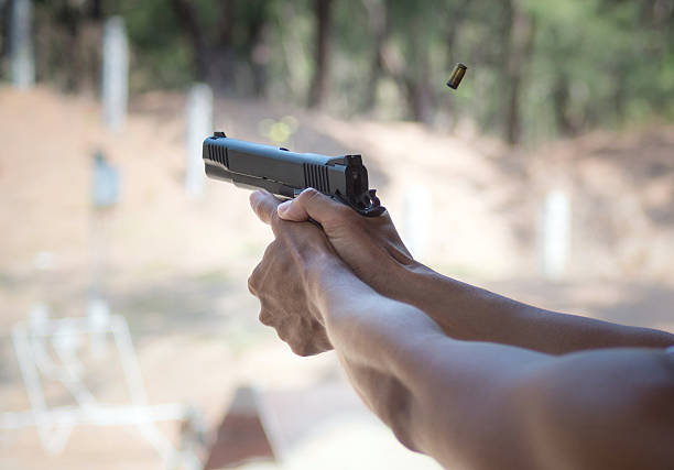 istock Man firing pistol at firing range 492022933