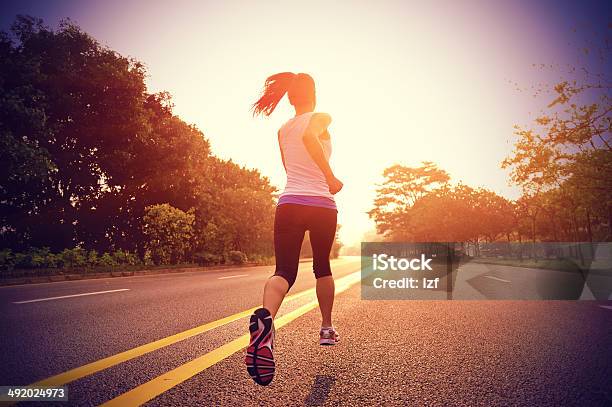 Frauen Läuft Auf Der Straße Am Frühen Morgen Stockfoto und mehr Bilder von Rennen - Körperliche Aktivität - Rennen - Körperliche Aktivität, Rückansicht, Frauen
