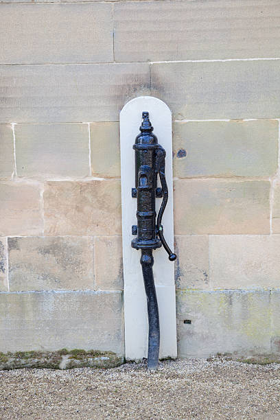 istock old hand operated water pump beside stone wall 492026575