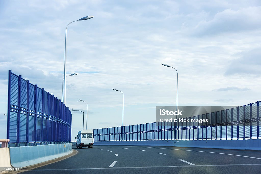 Delivery Van on Road White delivery van travelling on road. Asphalt Stock Photo