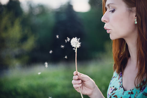 istock Girl blowing dandelion 492028283