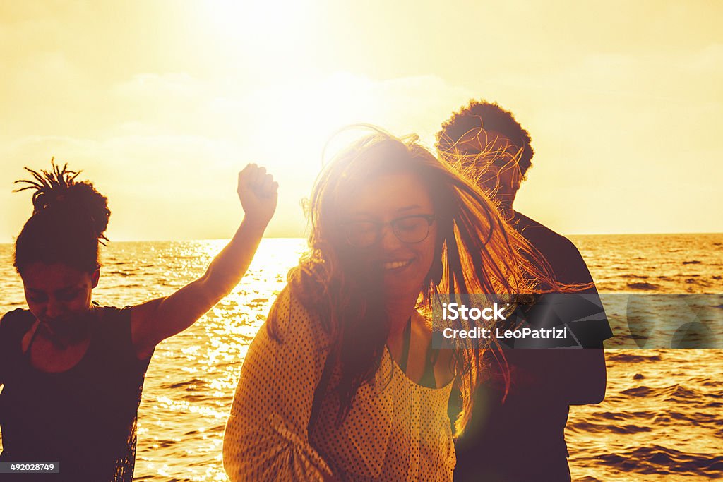 Group of multi-ethnic friends dancing on the beach Group of multi-ethnic friends dancing on the beach. 20-29 Years Stock Photo