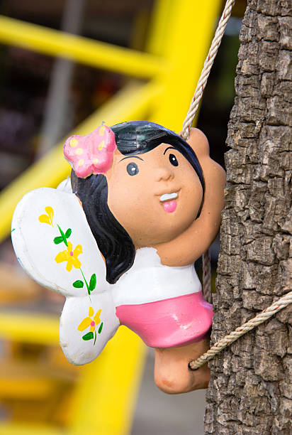 istock Doll- girl climbing trees. 492028883
