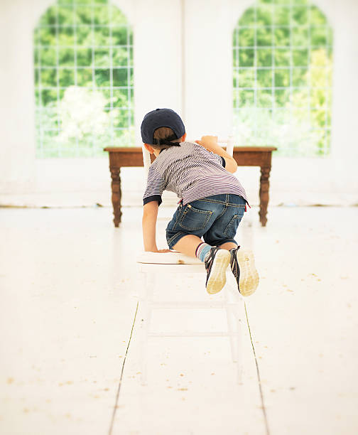 Cute little Asian child girl lying on Thai wooden traditional chair.