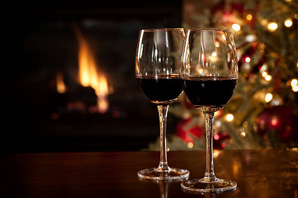 red wine in front of the fireplace at christmas time - wine christmas stockfoto's en -beelden