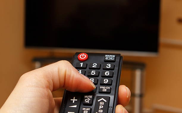 istock Hand holding remote control for television, choosing channel in TV 492037864