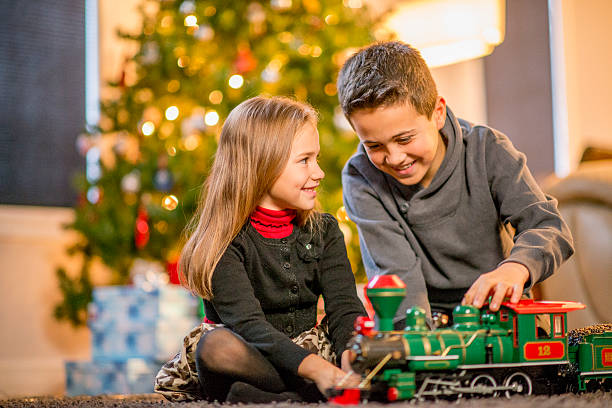 istock Siblings Playing with a Toy Train on Christmas Eve 492038974
